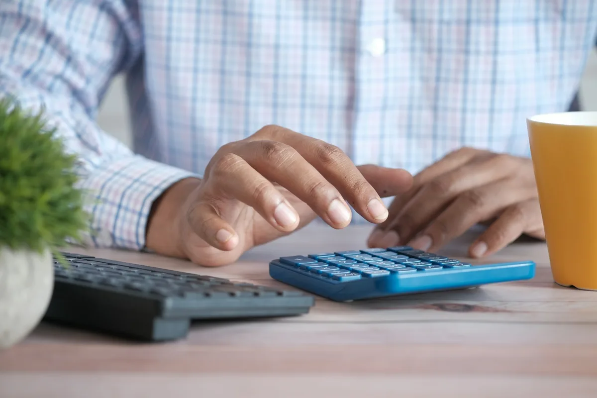 UK chartered accountant reviewing financial statements at a computer in a modern office