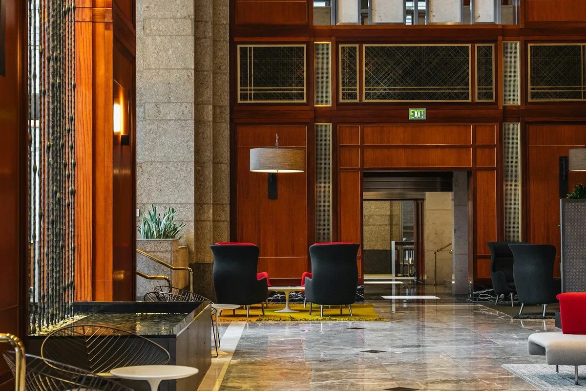 UK hospitality manager greeting guests at a luxury hotel reception desk
