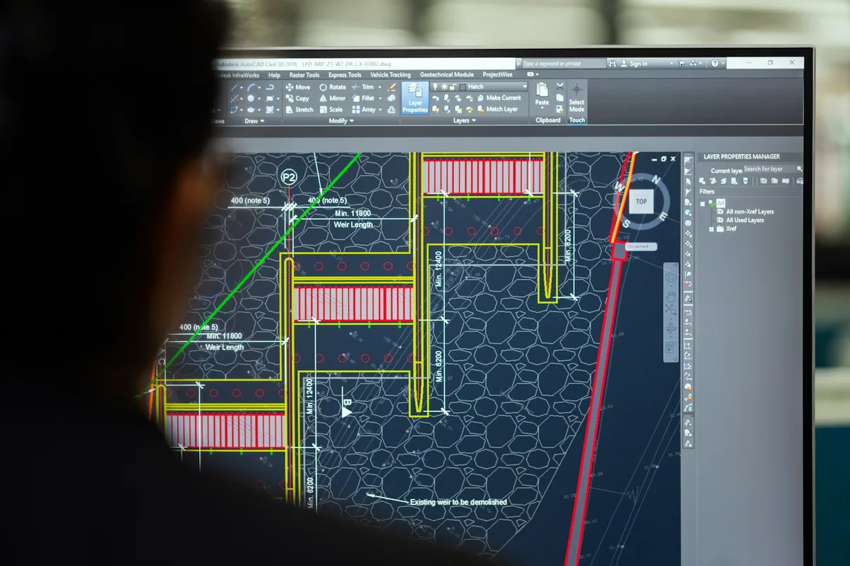 UK mechanical engineer working on CAD designs and physical prototypes in a modern engineering workshop