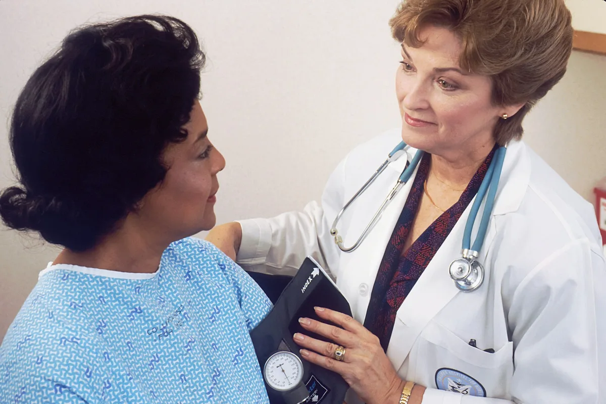 Compassionate UK mental health nurse listening to a patient in a calm clinical setting