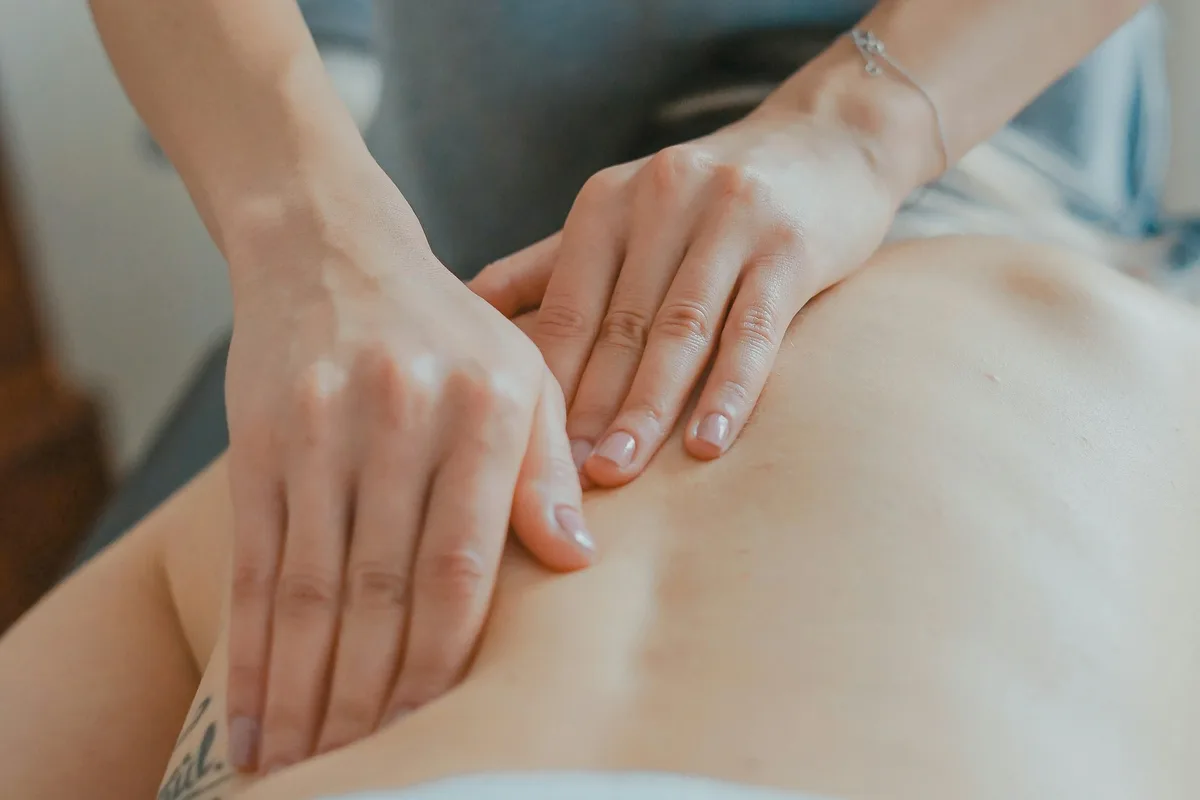 UK physiotherapist guiding a patient through a rehabilitation exercise in a modern clinic