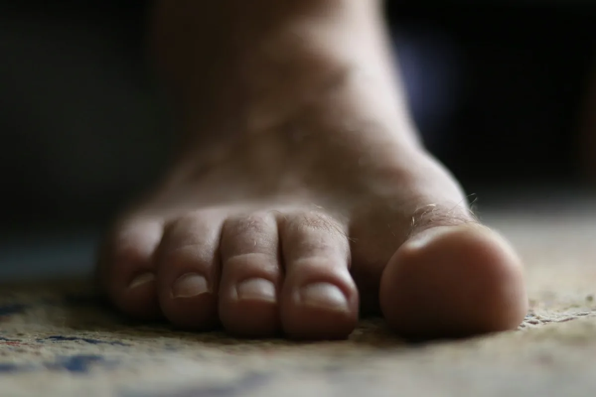 UK podiatrist examining a patient's foot in a modern clinic consultation room