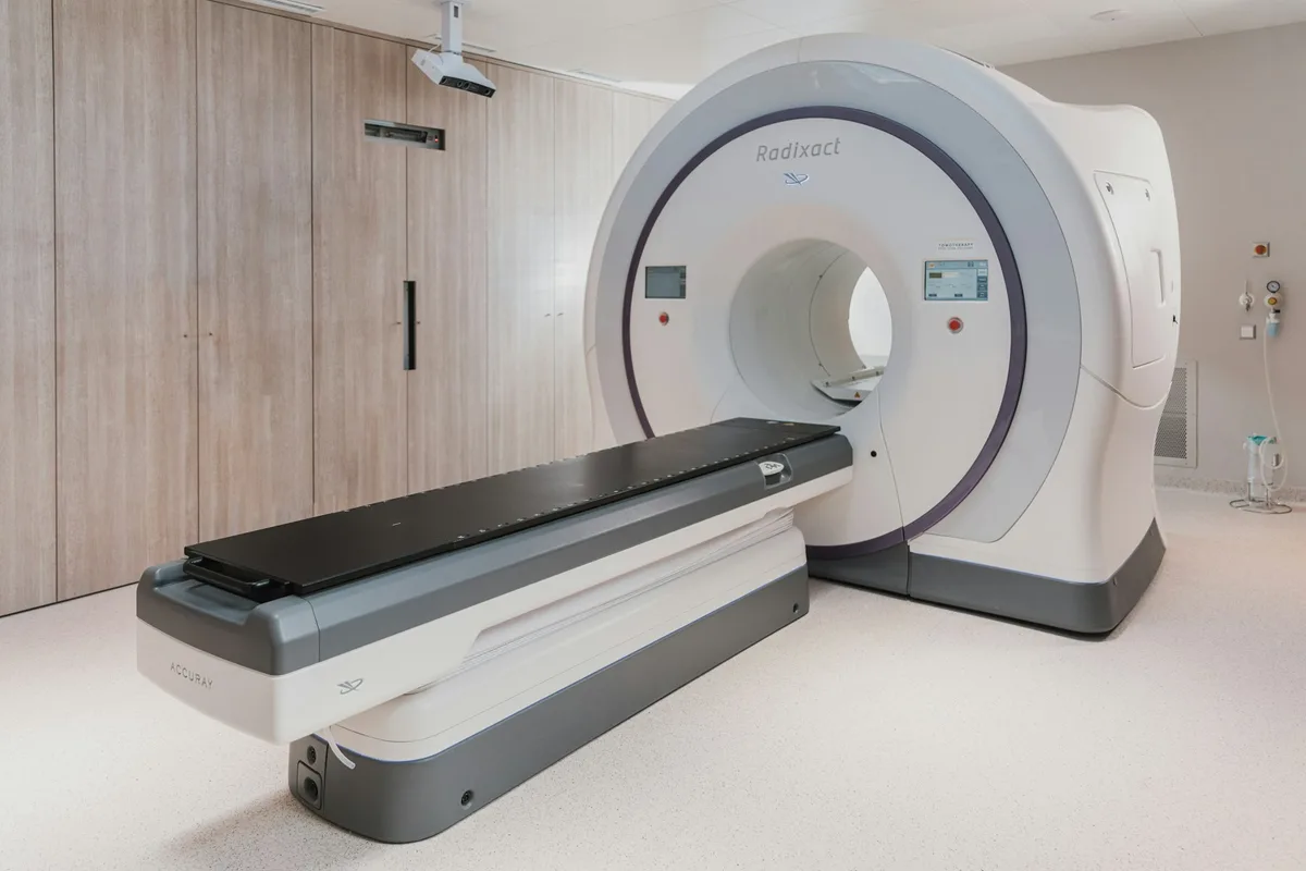 UK radiographer operating an MRI scanner control panel in a hospital imaging department