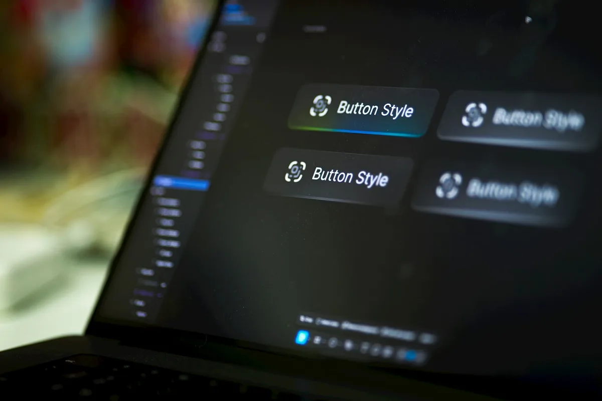 UK product designer sketching user-interface designs and reviewing Figma prototypes on a large monitor